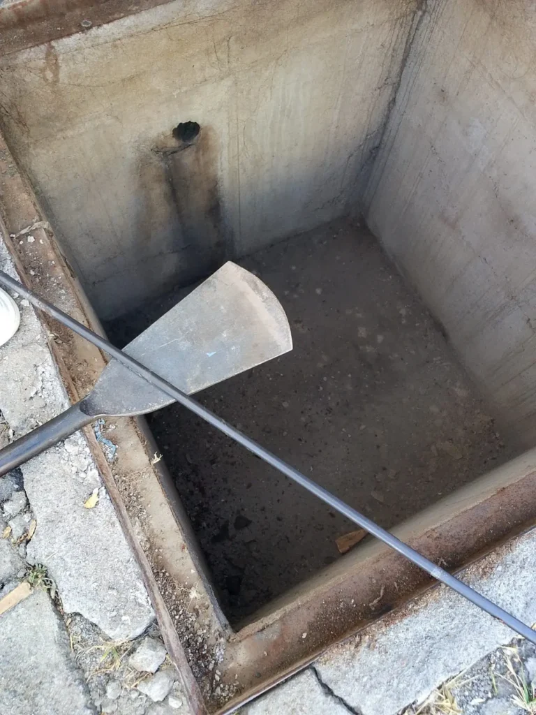 Técnico colocándose traje impermeable junto al camión de succión de pozos sépticos
